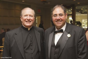 Father Holcomb smiles with Joseph Dorsa, parish finance director, at the anniversary dinner dance. (Photo by Robert H. Scott)
