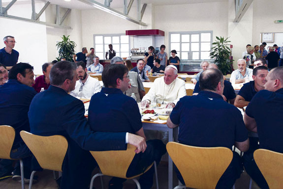 Pope Francis talks with Vatican workers during a surprise visit to the Vatican cafeteria July 25.