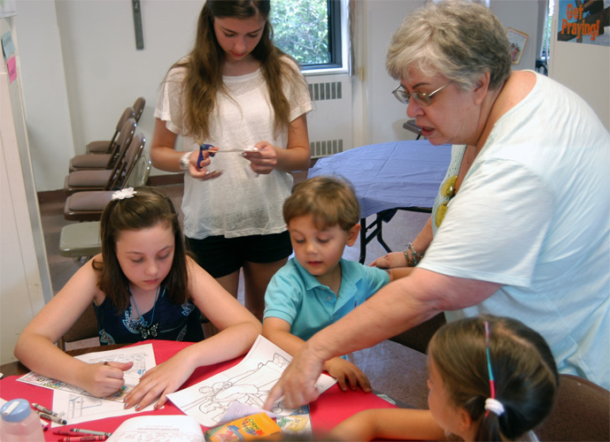 Volunteer Jane Donlon explains the Bible scenes campers are coloring.
