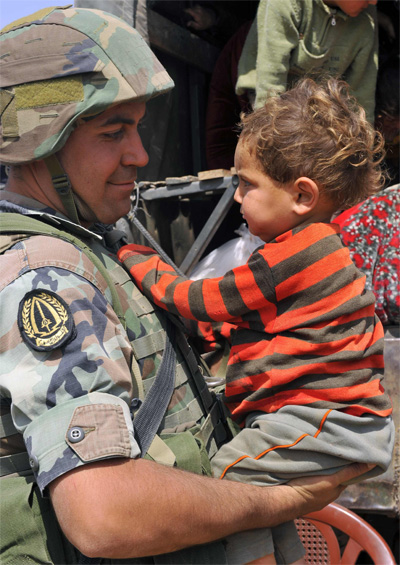Lebanese soldier holds child-refugee