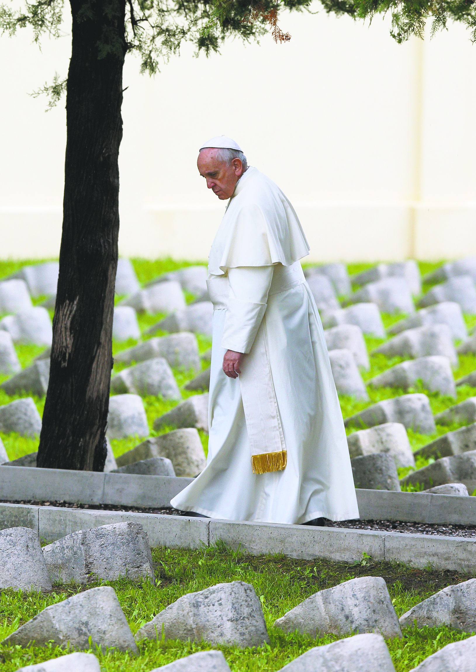Pope Francis looks at tombstones as he walks through Austro-Hungarian cemetery for World War I soldiers in Italy