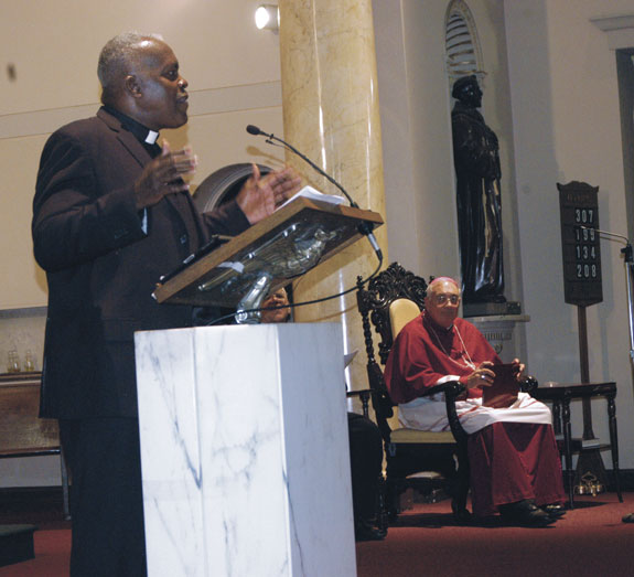 Bishop DiMarzio, far right, listens as Rev. Kevin B. Jones, pastor of Peterson Temple Church of God in Christ, Crown Heights, challenged people of faith to pray and take loving action to combat violence in their local communities.