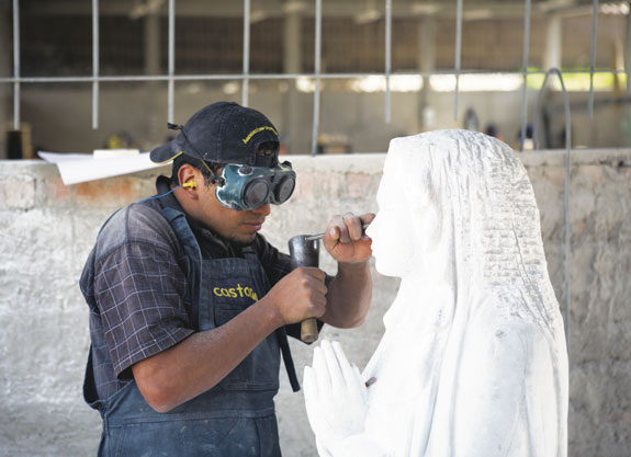 Freddy Cerna, above, carves a statue of Mary in Jangas, Peru. The marble statue, which takes three months to complete, will be sent to Lima. Yony Romero, bottom, paints a wooden panel with one of the Stations of the Cross.