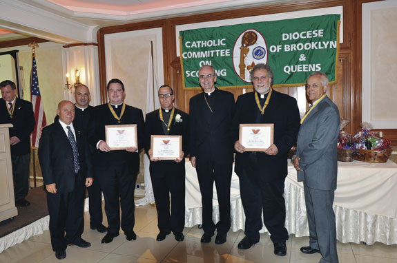 Bishop Paul Sanchez presents the Bronze Pelican Medals to Father Joseph Zwosta, Queens Chaplain for Scouting; Father Mark Simmons, Holy Name, Park Slope; and Father Richard Bretone, St. Patrick’s, Bay Ridge. Also shown at left are Brian Long and Father Thomas Vassalotti and at right, Henry Zalak, Good Scout honoree.