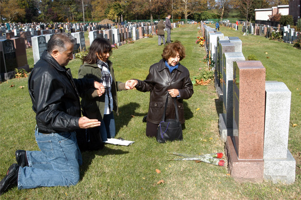Simancas, Rojas and Palacios pray before the grave of their loved ones.