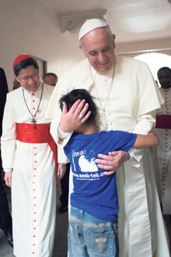 Pope Francis embraces boy in Philippines