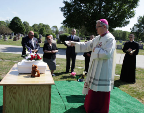 During a burial service at Gate of Heaven Cemetery in East Providence, R.I., Bishop Thomas J. Tobin blesses the casket containing the remains of a fetus found in the collection area of a wastewater treatment facility. Photo © Catholic News Service/Rick Snizek, Rhode Island Catholic