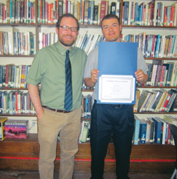 Ted Frank, library specialist, gives award to Christopher DiGeronimo.