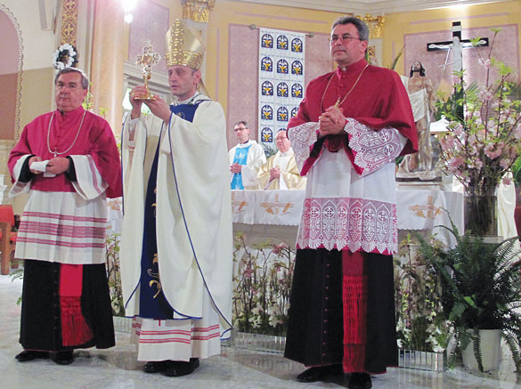 Then-Auxiliary Bishop Frank Caggiano holds up the relic of Blessed John Paul II for veneration at St. Frances de Chantal Church, Borough Park. At left is the pastor, Canon Andrzej Kurowski, and at right is Canon Witold Mroziewski.  