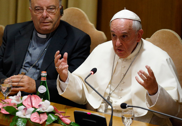 Pope Francis addresses mayors from around the world at a workshop on climate change and human trafficking in the synod hall at the Vatican July 21. Local government leaders were invited by the pontifical academies of sciences and social sciences to sign a declaration recognizing that climate change and extreme poverty are influenced by human activity. Also pictured is Cardinal Francesco Montenegro of Agrigento, Italy. (CNS photo/Paul Haring)