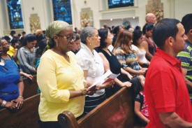 Women from the diocese join in the prayers at St. James Cathedral during a special Mass for Haitians being threatened with deportation from the Dominican Republic. (Photo by Ed Wilkinson)