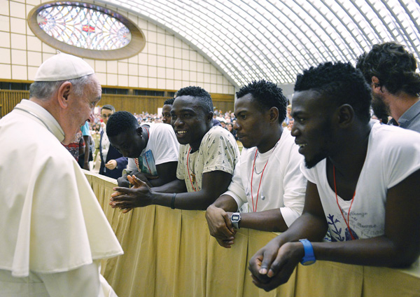 Pope Francis meets a group of Nigerian refugees at the Vatican Aug. 12. The pope will address the U.S. Congress and the U.N. General Assembly during his September U.S. visit and will discuss the idea of one human family and shared responsibility for others and the world. (Photo © Catholic News Service photo/L'Osservatore Romano via Reuters)