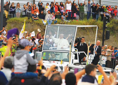Pope Francis greets the crowd from his popemobile, a Jeep Wrangler, as he arrives in Quito, Ecuador, July 5. The pontiff will use the same model during his visit to the United States in September. (Photo ©  Catholic News Service/Robert Puglla, EPA)