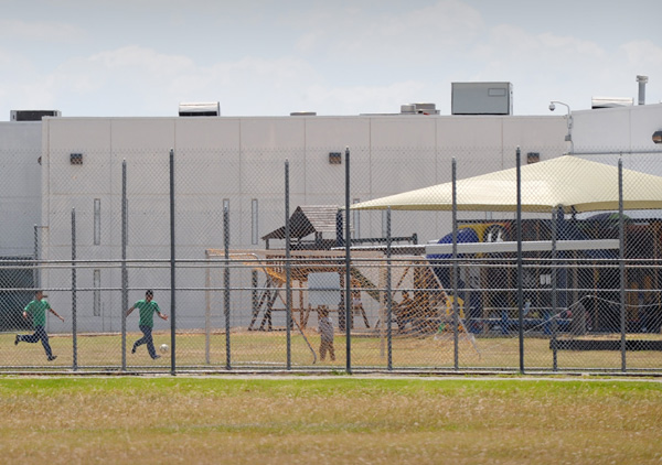 Children play in a double-fenced playground area in 2009 outside the T. Don Hutto Family Residential Facility in Taylor, Texas. The Catholic Legal Immigration Network and the Sisters of Mercy of the Americas decried the Obama administration's effort to have a judge set aside her orders for the release of families being held in immigration detention centers. (CNS photo by Bahram Mark Sobhani)
