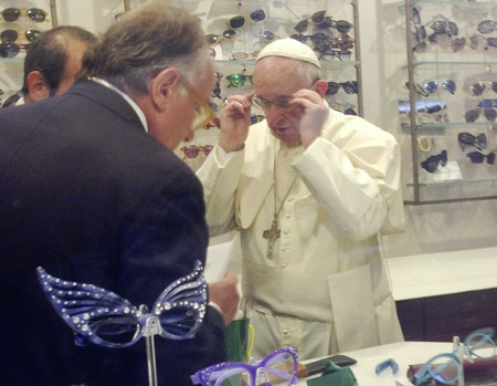 Pope Francis tries on a pair of glasses in an optical store in downtown Rome Sept. 3. Romans and tourists crowded outside the shop to catch a glimpse of the pope inside as he had his eyes measured for a new set of bifocal lenses. (Photo © Catholic News Service/Chiara Apollonj, Reuters) 