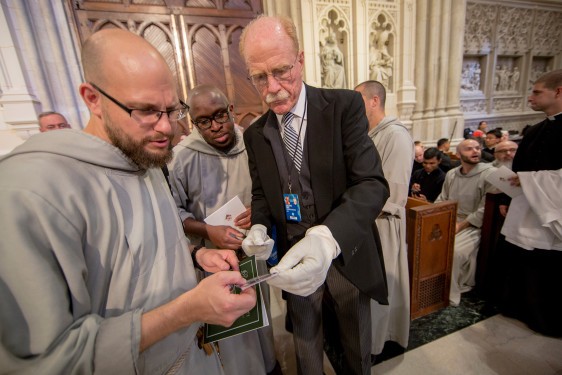 An usher helps two monks find seats. Photo © Catholic News Service/Mike Crupi