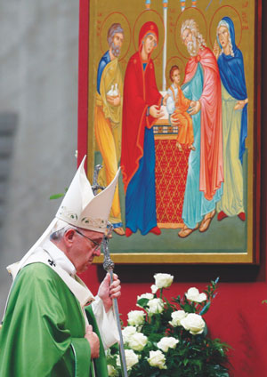 Pope Francis walks past an image of the Holy Family as he leaves after celebrating the closing Mass of the Synod of Bishops on the family in St. Peter’s Basilica at the Vatican Oct. 25. 