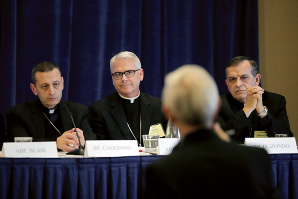 Bridgeport Bishop Frank J. Caggiano, Archbishop Paul S. Coakley of Oklahoma City, Okla., chairman of Catholic Relief Services, and Seattle Auxiliary Bishop Eusebio L. Elizondo listen to a reporter’s question during a news conference at the 2015 fall general assembly of the U.S. Bishops. (Photo © Catholic News Service/ Bob Roller)