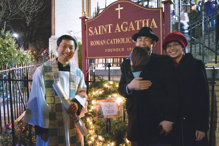 Father Vincentus Do, pastor of St. Agatha, shows the Ng family the wreath they sponsored during the parish’s first Christmas tree lighting ceremony. The Lights at St. Agatha will shine bright until Jan. 10, 2016. (Photo © Antonina Zielinska)