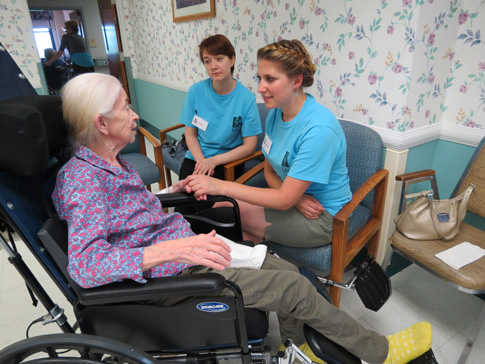 Stacey Jackson, front center, a graduate of Seton School in Manassas, Va., and Amy Endres speak with nursing home resident Kathleen Grace in early July during this summer’s pilot of SALT, a mission program hosted by the Carmelite Sisters for the Aged and Infirm. (CNS photo/courtesy Carmelite Sisters for the Aged and Infirm)