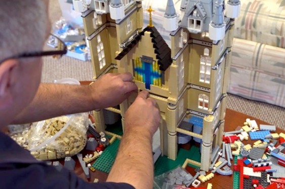Father Bob Simon, pastor of St. Catherine of Siena parish in Moscow, Pa., places a LEGO piece on a model church he is building in a spare room in his rectory Oct. 24. (Photos © Catholic News Service/ Chaz Muth)