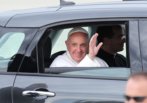 Pope Francis waves from a Fiat 500 L sedan as he leaves the airfield at Joint Base Andrews in Maryland Sept. 22. The Archdiocese of Philadelphia is auctioning off two of the same model cars used to shuttle Pope Francis around the Philadelphia area during his visit to the city last September. (Photo © Catholic News Service/ Bob Roller)