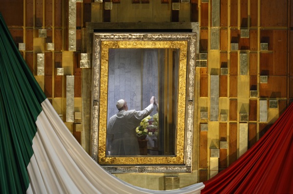 Pope Francis touches the original image of Our Lady of Guadalupe after celebrating Mass in the Basilica of Our Lady of Guadalupe in Mexico City Feb. 13. The Marian image was rotated for the pope to pray in the "camarin" ("little room") behind the main altar. (CNS photo/Paul Haring) See POPE-GUADALUPE Feb. 13, 2016.