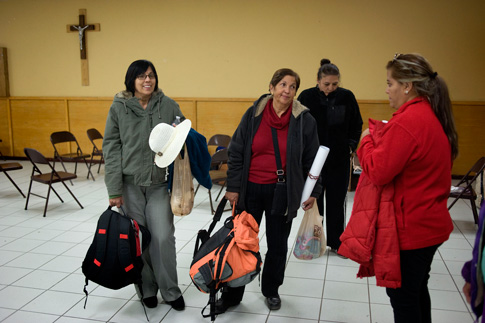 People chat with their belongings in Lord of Mercy Church in the evening of Feb. 16 in Ciudad Juarez, Mexico. They are part of a group of 20 people who traveled to Ciudad Juarez to attend a Feb. 17 Mass celebrated by Pope Francis in Ciudad Juarez. Thousands of pilgrims are staying at parishes around the city or are being accepted into the homes of parishioners. (CNS Photo/David Maung)