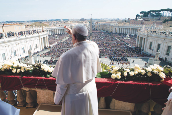 Pope Francis greets the crowd during his Easter message and blessing delivered from the central balcony of St. Peter’s Basilica at the Vatican.