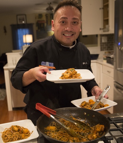 Celebrity chef Father Leo Patalinghug displays a Lenten seafood pasta meal he prepared in his Baltimore kitchen Feb. 24. (CNS photo/Chaz Muth) 