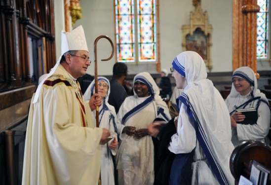 Auxiliary Bishop Witold Mroziewski chats with Missionaries of Charity at Our Lady of Victory Church following a memorial Mass for the four members of the Order who were killed in Yemen. 