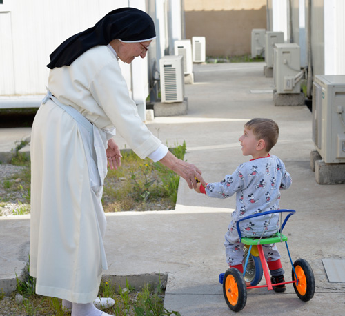 Dominican Sister Elene greets 2-year old Yusef Firas in Ankawa, Iraq, April 7. The Islamic State group displaced the nun and boy's family from Mosul in 2014. (Photo © Catholic News Service/ Paul Jeffrey)