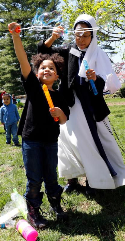 A child and Sister Antoniana Maria, S.V. play with bubbles at the Sisters of Life retreat house in Stamford, Conn.
