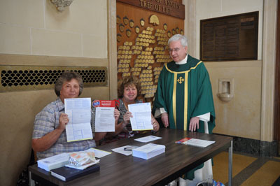 Anne D’Antuono and Muriel Wilkinson show off voter registration forms at Our Lady of Angels parish, Bay Ridge, as the pastor, Msgr. Kevin Noone encourages their efforts.