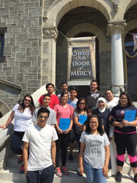 St. Bartholomew parishioners going to World Youth Day ­– including the parish’s faith formation coordinator, Sister Lucy Mendez, P.C.M. – pose in front of the Shrine of the Miraculous Medal, which houses one of six Holy Doors of Mercy in the Archdiocese of Philadelphia. (Photo © Rob Cote)