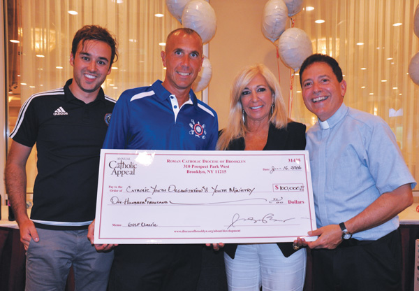 Msgr. Jamie Gigantiello and honored guest Judge Patricia DiMango, who appears on the TV court show Hot Bench, present a check for $100,000 from the CYO Golf Outing to CYO director Rob Caldera and Carlos Rafael Moerson, representing New York City Football Club. (Photo © Rita Damato)