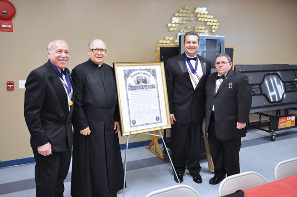 The Knights of Columbus Council at Holy Family parish, Fresh Meadows has changed its name to Holy Family - Bishop Ignatius Catanello Council in honor of the late auxiliary bishop and pastor. The unveiling of the new charter took place last weekend, above. Present were, from left, Tony Civitano, Father Casper Furnari, pastor; Grand Knight Peter Petrino, and Past Grand Knight Joseph Healey.
