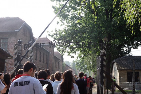 p World Youth Day pilgrims from Brooklyn walk through the main gate into Auschwitz concentration camp during a visit prior to WYD activities. (Photo: Catholic News Service/Bob Roller)