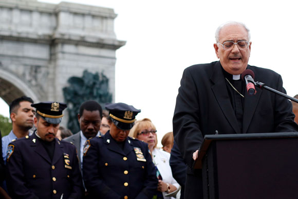 Bishop Nicholas DiMarzio prays during a candlelight vigil July 11 at Grand Army Plaza in the Prospect Heights section of Brooklyn. The interfaith service was organized by the Diocese of Brooklyn to mourn the victims of fatal shootings by police in Louisiana and Minnesota earlier this month and the five police officers subsequently killed by a sniper in Dallas.