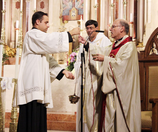  Msgr. Guy Massie, pastor, and Father Michael Tedone, parochial vicar at St. Bernard Church, Mill Basin, are joined on the altar by pastoral associate, John Heyer II. 