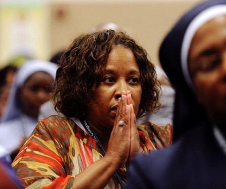 A woman prays during the opening Mass of the Third African National Eucharistic Congress.