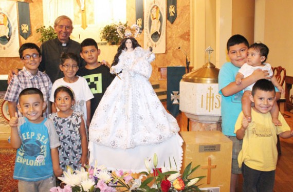 Father Diego Villegas and children from St. Leo’s gather around the statue of Our Lady of Cisne. (Photo: Jim Mancari) 
