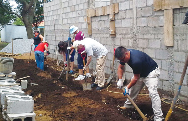  Members of St. Kevin’s Mission Team from Flushing, including Father Paul Kim, right, dig a ditch for a water pipe at the Mustard Seed Community in Nicaragua. 