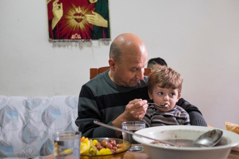 Iraqi refugee Sami Dankha, 51, feeds his son Alin, 1, at his home in Istanbul, Turkey. He lives in Istanbul with his wife and five children; his brothers live in New Zealand, Australia and the Netherlands. (CNS photo/Oscar Durand) 