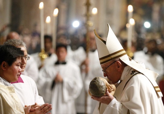 Pope Francis kisses a figurine of the baby Jesus at the conclusion of Christmas Eve Mass in Peter's Basilica at the Vatican Dec. 24. (CNS photo/Paul Haring) See POPE-CHRISTMAS Dec. 25, 2016.