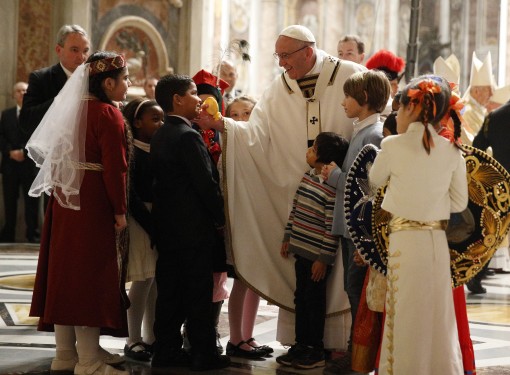 Pope Francis greets children at the conclusion of Christmas Eve Mass in Peter's Basilica at the Vatican Dec. 24. 