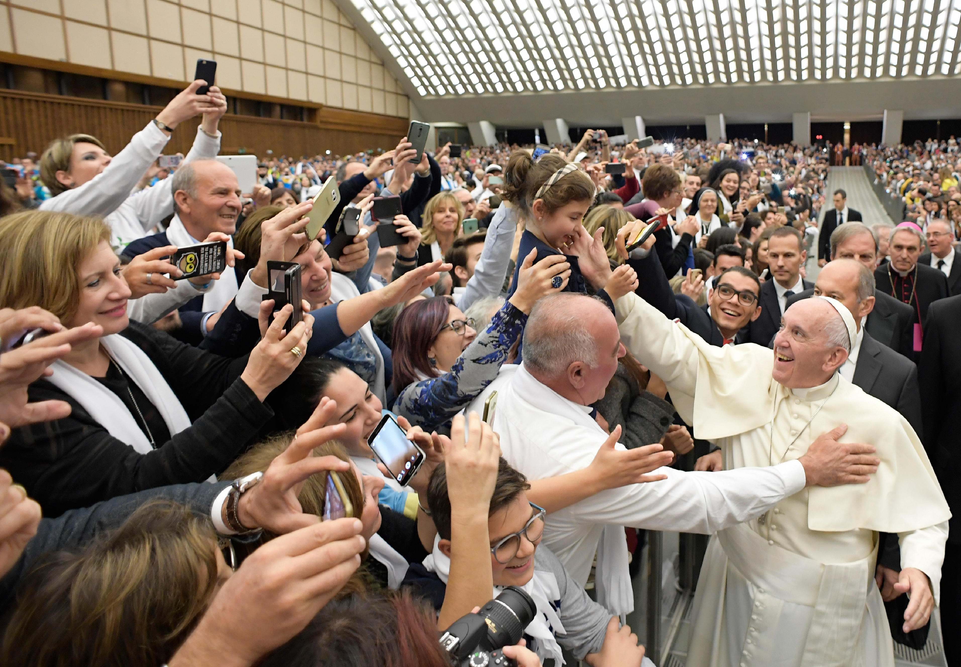 Pope Francis greets the crowd during an audience with young volunteers, government officials and organizations involved in Italy's national civil service programs, in Paul VI Hall at the Vatican Nov. 26. (CNS photo/L'Osservatore Romano, handout) See POPE-VOLUNTEERS Nov. 28, 2106.