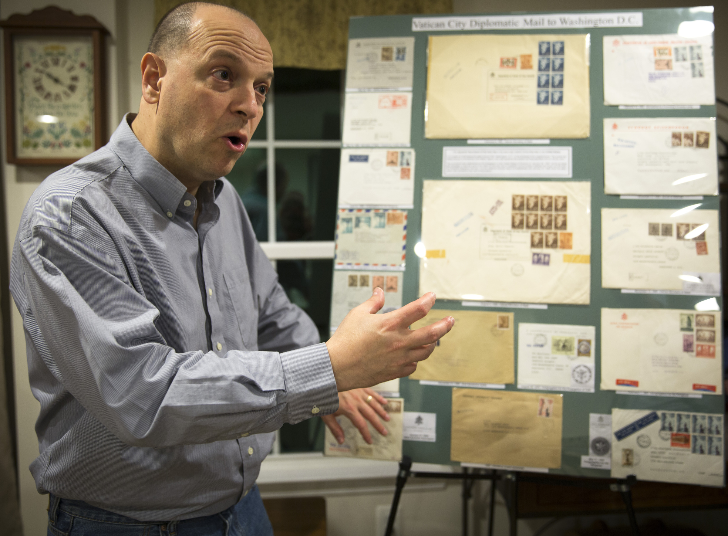 Greg Pirozzi, president of the Vatican Philatelic Society, points out a board displaying some of his Vatican stamps, notes, covers and reference material at his Hanover, Md., home Nov. 1. (CNS photo/Chaz Muth) See VATICAN-PHILATELIC-SOCIETY Nov. 10, 2016.