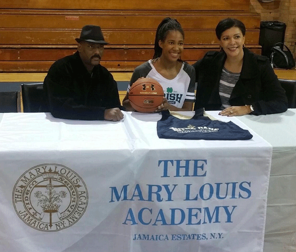 Danielle Patterson, a senior forward at The Mary Louis Academy, Jamaica Estates, shows off the colors of the Irish at a press conference announcing her intent to attend Notre Dame University. Her parents, Lamont and Danielle, look on.