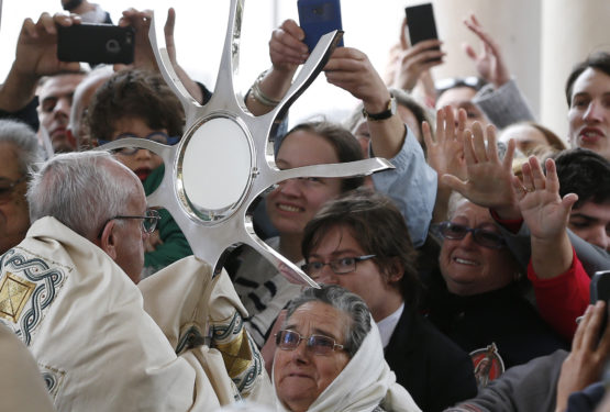 Pope Francis blesses the sick with the Eucharist at the conclusion of the canonization Mass of Sts. Francisco and Jacinta Marto, two of the three Fatima seers, at the Shrine of Our Lady of Fatima in Portugal May 13. The Mass marked the 100th anniversary of the Fatima Marian apparitions, which began on May 13, 1917. (CNS photo/Paul Haring) 